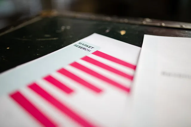 A detailed close-up of a market research document featuring a bar graph and a focus on market trends. How do you carry out sponsorship rates competitor research?