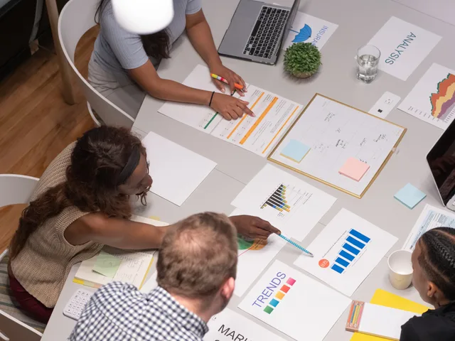Team of professionals collaborating on a business project, analyzing charts and graphs in an office setting. Sponsorship rates service standards for brand deals: four promises worth writing down