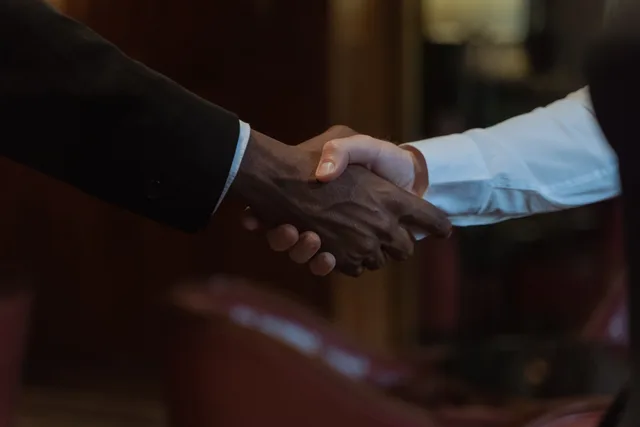 Close-up of a diverse handshake, representing business collaboration and diversity. What should you look for in sponsorship rates tools and providers?